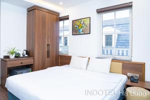 a bedroom with a white bed and a window at INDOTEL HALONG HOTEL in Ha Long +93 photos