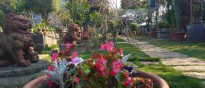 un jardín con estatuas y flores en un patio en Elegant Stay en Liujiao