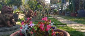 a garden with statues and flowers in a yard at Elegant Stay in Liujiao