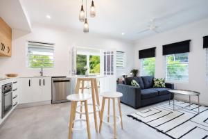 a kitchen and living room with white cabinets and a blue couch at Bamboo Villa - Pet friendly luxury Villa next to Botanical Gardens in Edge Hill