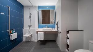 a bathroom with a sink and a mirror at Holiday Inn Express Shanghai Qingpu New City, an IHG Hotel in Shanghai