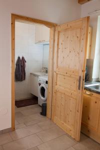 a door to a kitchen with a washing machine at Kellerstöckl am NaturGut Kunterbunt in Hartl