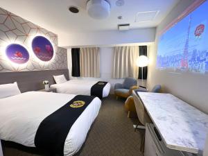 a hotel room with two beds and a large screen at Grand Park Hotel Panex Kimitsu in Kimitsu