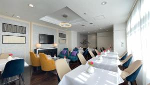 a conference room with tables and chairs and a tv at Grand Park Hotel Panex Kimitsu in Kimitsu