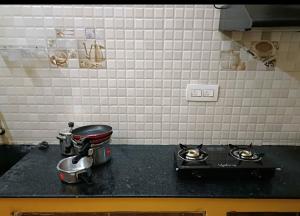a kitchen with two pots and pans on a stove at WHITE HOUSE SERVICE APARTMENT in Madurai