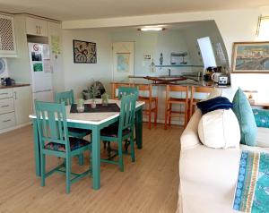 a kitchen and living room with a table and chairs at Langebaan Paradise Beach 9 Elara in Langebaan