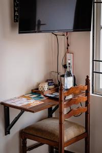 a table with two chairs and a television on a wall at Casa Mel in Puducherry