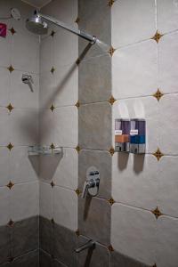 a bathroom with a shower with a tile wall at Casa Mel in Puducherry