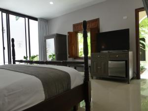 a bedroom with a bed and a flat screen tv at Casa Valladolid Boutique Hotel in Valladolid