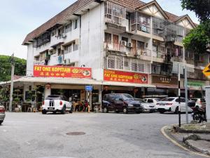 een gebouw met auto's geparkeerd voor een straat bij 3 Rooms 2 parking 10pax PSR Comfy Sofa&Bed near MRT Eateries McD in Seri Kembangan