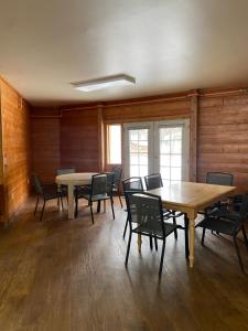 Habitación con mesas y sillas en una habitación con paredes de madera. en Soldotna Lodge, en Soldotna