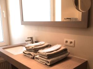 einen Haufen Handtücher auf einem Waschbecken in der Unterkunft Residentie De Laurier in Knokke-Heist