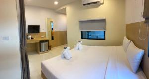una camera d'albergo con due bambole sedute su un letto di I Am O'TEL PATONG Managed by Priew Wan Guesthouse a Patong Beach