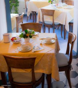 a table with a yellow table cloth on top of it at B&B Villa Clodia in Saturnia