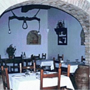 jadalnia ze stołem, krzesłami i łukiem w obiekcie Agriturismo Villa Gabbiano w mieście Capodacqua