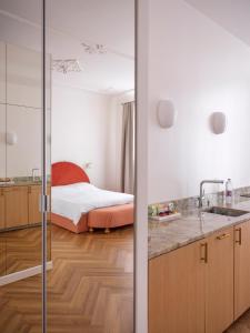 a bathroom with a bedroom with a bed in the background at MIRO Rooms - quiet chic, free parking, self check-in in Rīga