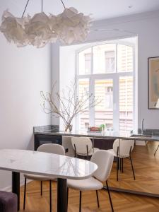 a dining room with a table and chairs at MIRO Rooms Skolas - quiet chic, free parking, self check-in in Rīga