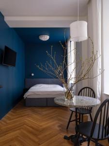 a bedroom with blue walls and a table with chairs at MIRO Rooms - quiet chic, free parking, self check-in in Riga