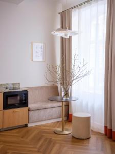 a living room with a couch and a table at MIRO Rooms Skolas - quiet chic, free parking, self check-in in Rīga +26 photos