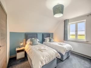 a bedroom with two beds and a window at The Pastures - Uk41853 in Maltby le Marsh