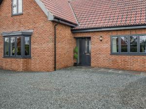 a brick house with a door and a gravel driveway at The Pastures - Uk41853 in Maltby le Marsh