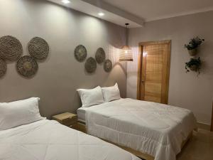 a bedroom with two beds and plates on the wall at LUXURY IN LAS TERRENAS AMARE in Santa Bárbara de Samaná