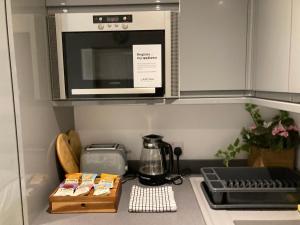 a kitchen counter with a microwave above a stove at Beautiful 1-Bed studio in Penrith in Penrith