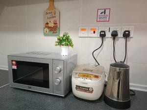 a kitchen counter with a microwave and a blender at A.Foo Homestay 4.0 @ Vivacity Megamall Jazz Suite 4 in Kuching