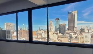 una finestra da ufficio con vista sullo skyline della città di Pacifico Apartment a Buenos Aires