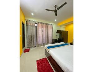 a bedroom with a bed and a ceiling fan at Hotel Satkar, Pithoragarh in Pithorāgarh