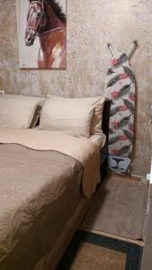 a bedroom with a bed and a horse painting on the wall at APARTAMENT-DAMO in Pamporovo