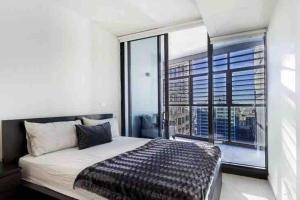 a bedroom with a bed and a large window at Luxury Stay in Sydney CBD in Sydney