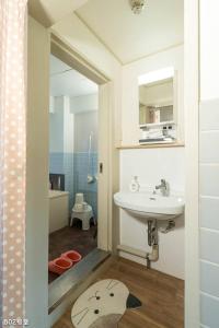 W łazience znajduje się umywalka, toaleta i lustro. w obiekcie Nanei Building - Vacation STAY 03606v w mieście Kagoshima