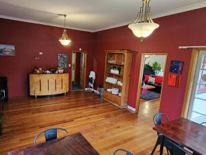 a living room with red walls and wooden floors at The Garston Lodge in Garston