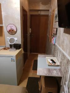 a small kitchen with a refrigerator and a table at APARTAMENT-DAMO in Pamporovo +14 photos