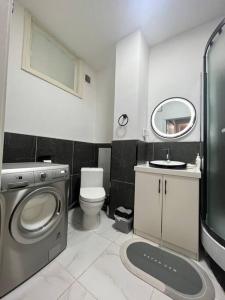 a bathroom with a washing machine and a sink at Comfy apartment in the heart of Ulaanbaatar in Ulaanbaatar