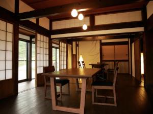 een eetkamer met een houten tafel en stoelen bij Tanekura Inn 