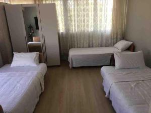 een hotelkamer met 2 bedden en een spiegel bij Sahile 200 metre uzaklıkta bahçeli dublex Yenifoça in Yenifoça