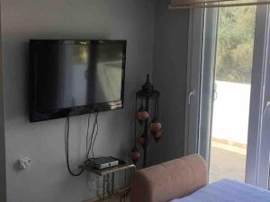 una TV a schermo piatto appesa a un muro di Sahile 200 metre uzaklıkta bahçeli dublex Yenifoça a Yenifoca