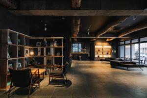 a large room with tables and chairs and windows at MURE Beppu in Beppu