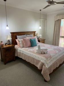 a bedroom with a large bed with pink and blue pillows at Lakefront Beauty ! Pet friendly in Yarrawonga