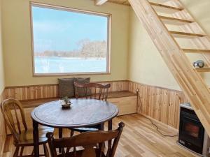 ein Esszimmer mit einem Tisch, Stühlen und einem Fenster in der Unterkunft Forest-House-Ranapirica - Vacation STAY 52421v 
