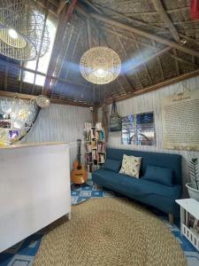 a living room with a blue couch and a rug at Beachfront Glamping with Mini Pool Exclusive Property in Lingayen