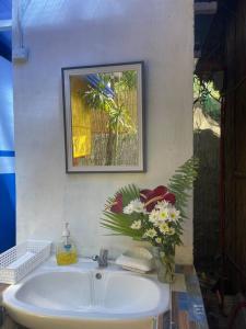 a bathroom sink with a vase of flowers on it at Beachfront Glamping with Mini Pool Exclusive Property in Lingayen +68 photos