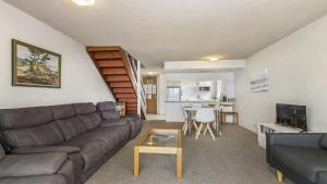 uma sala de estar com um sofá e uma mesa em 60 Beachpark Apartments - 58 Pacific Drive em Port Macquarie
