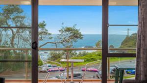 uma vista a partir da varanda de uma casa com uma mesa e cadeiras em 60 Beachpark Apartments - 58 Pacific Drive em Port Macquarie