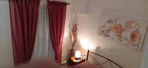 a room with a red curtain and a table with a lamp at Angela's Seaside Luxury Flat in Lefkandi Chalkidas
