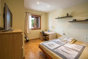 sypialnia z łóżkiem, biurkiem i telewizorem w obiekcie Carles w mieście Vilafranca de Bonany