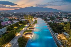 清迈Astra Sky River Paronama Pool Luxury Changklan Chiang Mai的夜晚的城市河流景观