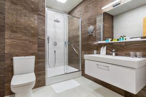 a bathroom with a shower and a toilet and a sink at Wyndham Baku in Baku